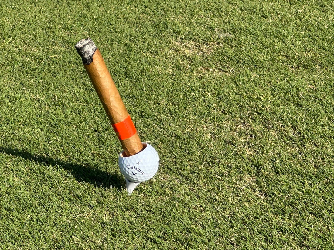 Golfball Zigarrenhalter Set mit Zigarre auf einem Tee im Rasen – perfektes Geschenk für Golfer.