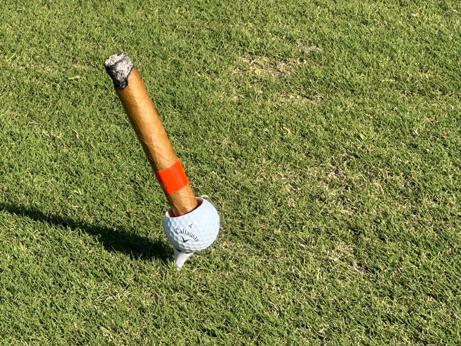 Golfball Zigarrenhalter Set mit Zigarre auf einem Tee im Rasen – perfektes Geschenk für Golfer.